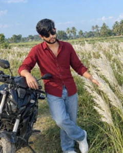 Man standing beside a motorcycle in a flower field
